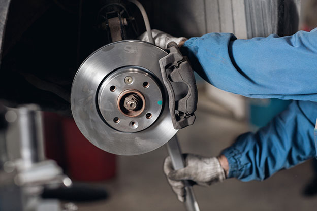 Brand new brake disc on car in a garage