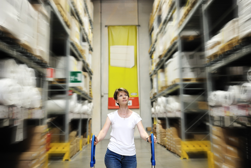 woman pushing cart through factory aisle