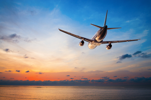 plane flying into sunset