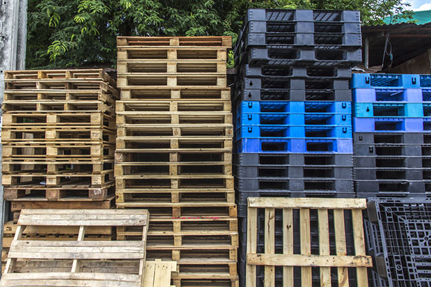 stacks of wooden and plastic pallets
