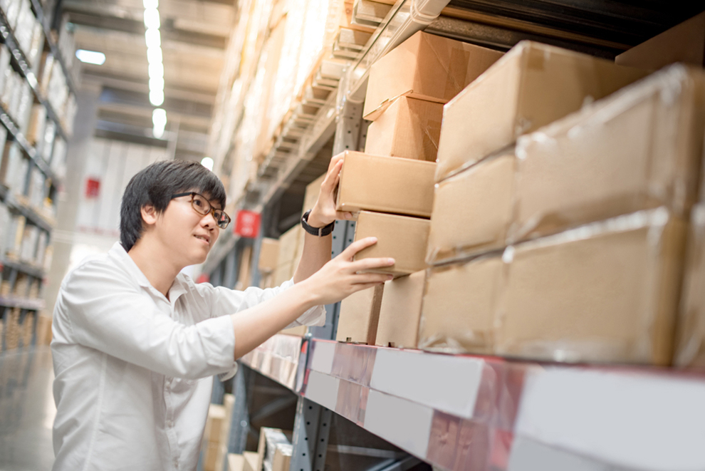 a worker picking a box from a shelf