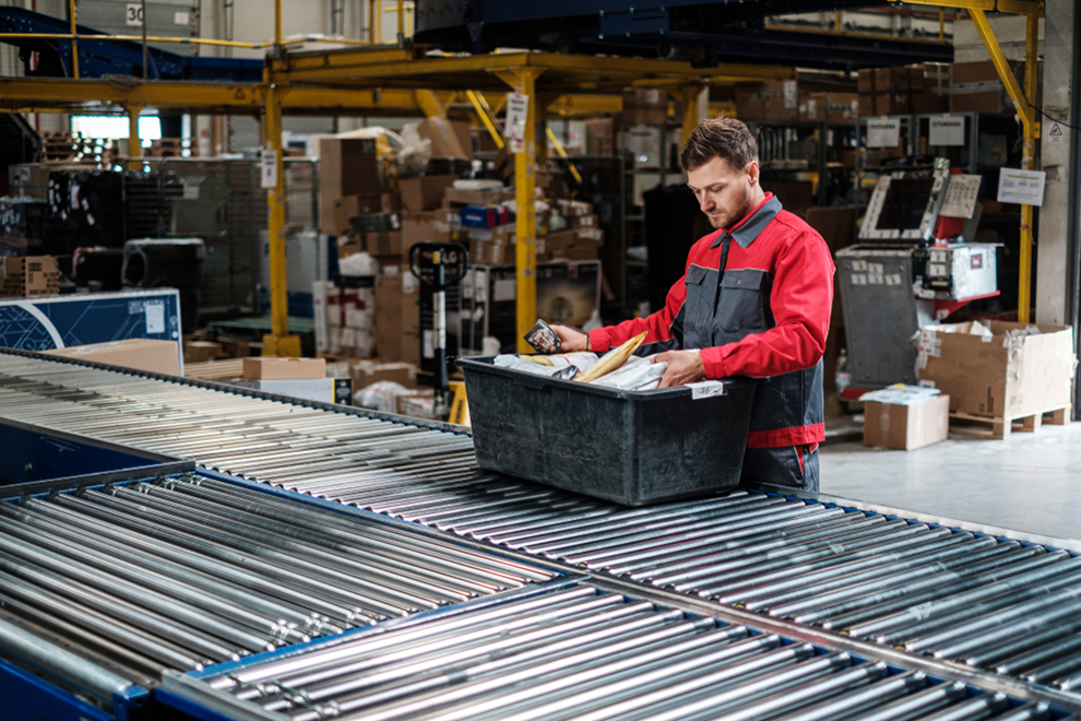 a worker checking a bin on a conveyor line