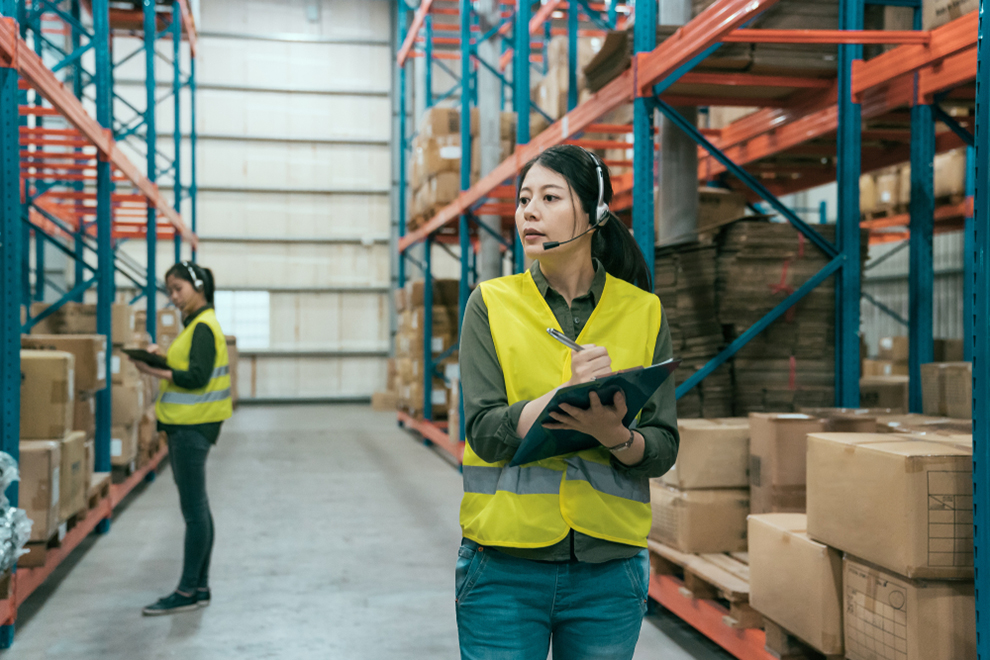 Woman with clipboard in Safety Vest at Warehouse. Стоковое фото. Женщины на складе приколы. Spotlight by Warehouse платье.