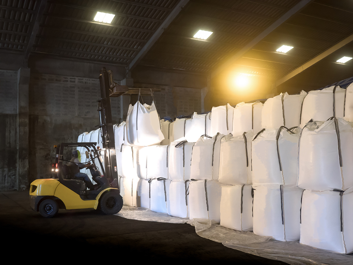 a forklift stacking large white sacks