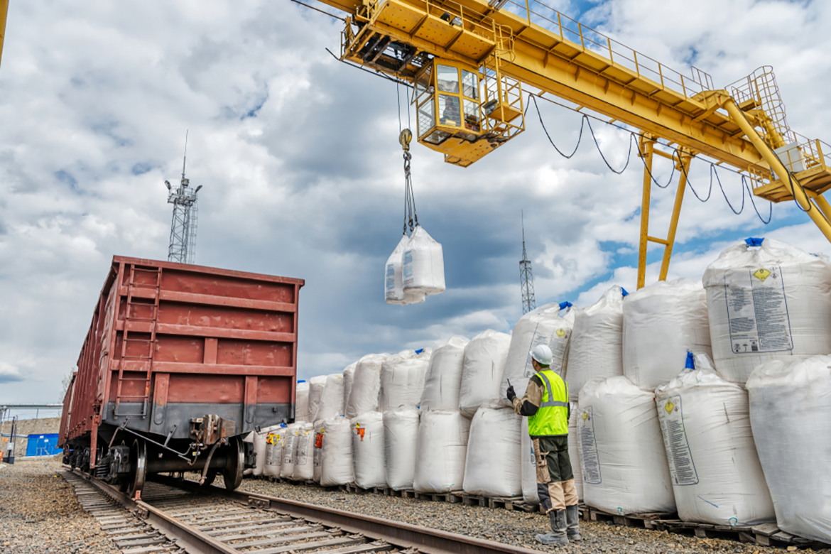 a shipment of large white sacks being moved with a crane