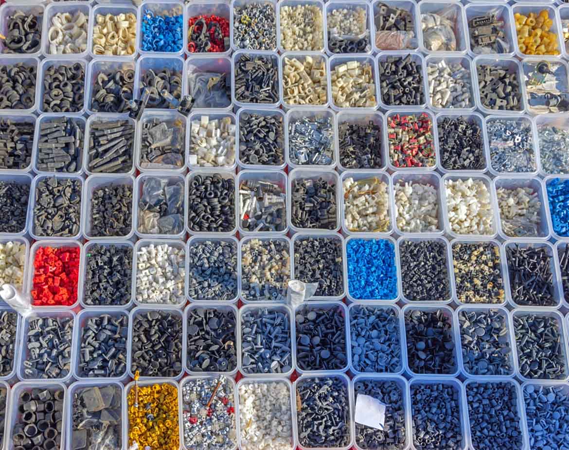 various parts sorted in plastic bins
