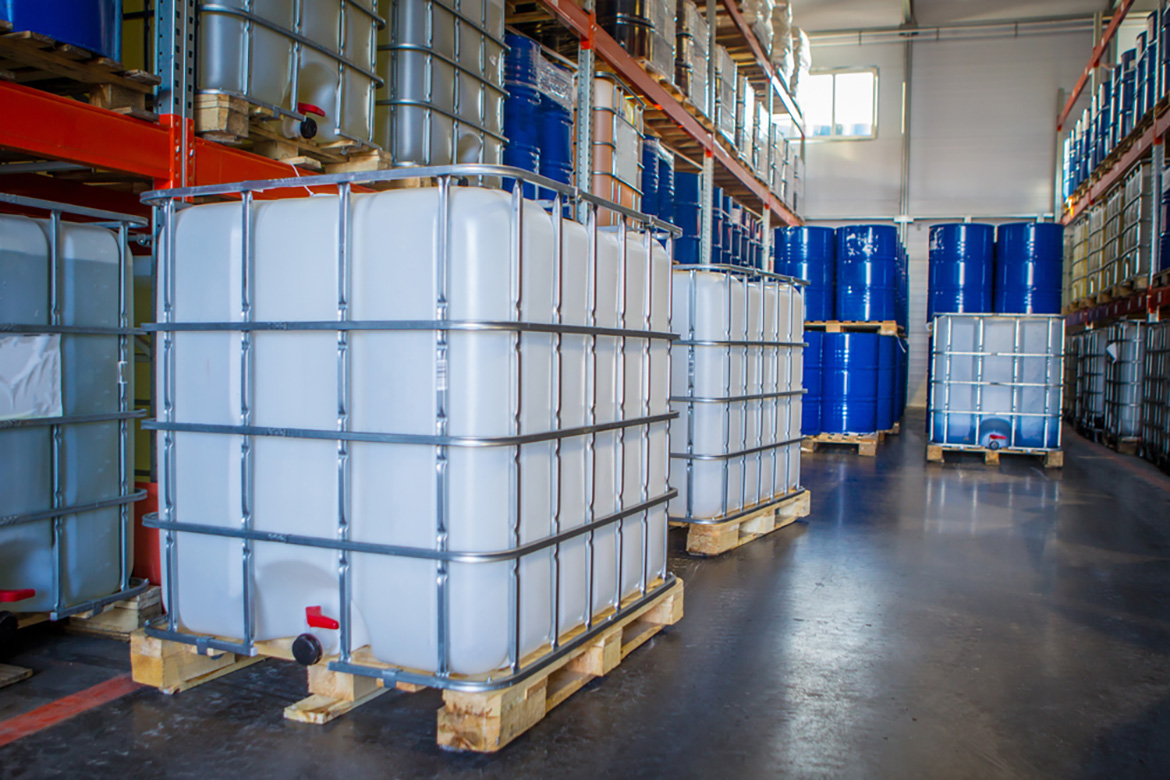 a warehouse with ibc totes and drum barrels on pallets